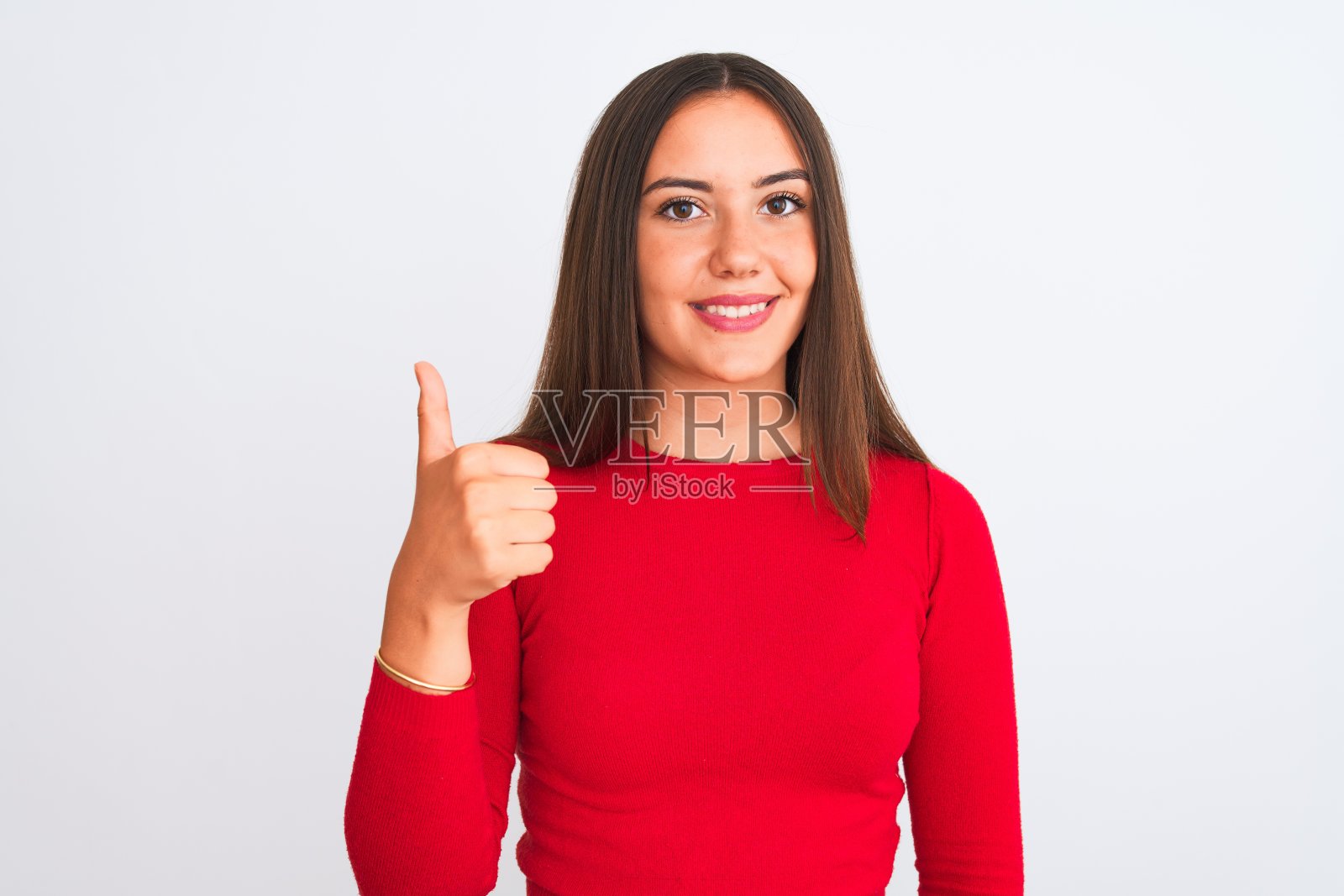 穿着红色休闲T恤的年轻漂亮女孩竖起大拇指，面露喜色照片摄影图片
