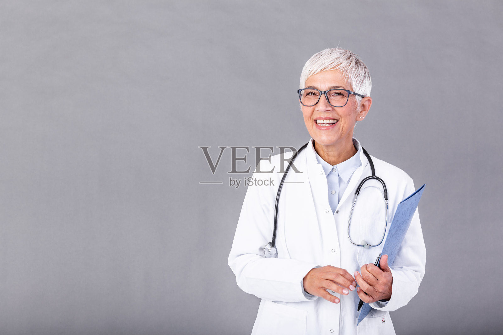 拥有医疗记录和听诊器的成熟女性医生。医疗保健和医疗理念。内科医生与听诊器隔离的背景。照片摄影图片