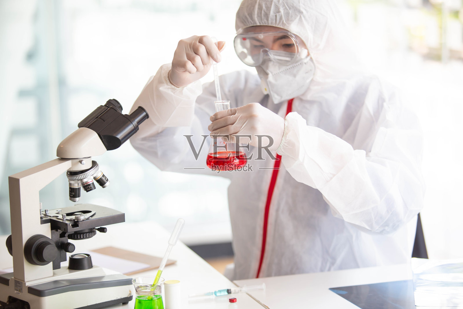 医生正在检测被新型冠状病毒感染的生物试管样本，寻找疫苗或抗病毒糖浆。在实验室和受感染的肺部胶片样本照片摄影图片