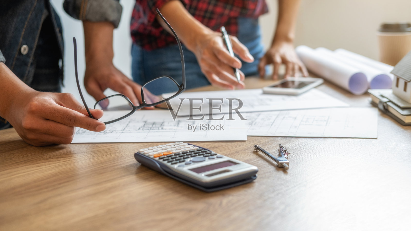 工程师或建筑师在办公室与建筑模型和设计图一起工作。建筑的概念。照片摄影图片