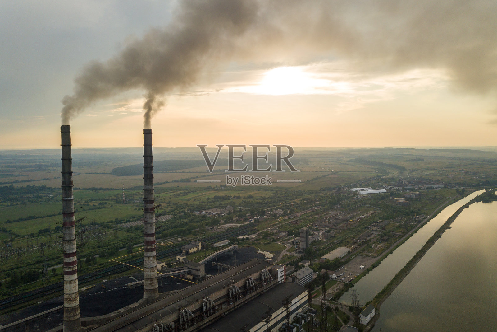 鸟瞰图的高烟囱管道与灰色烟雾从煤电厂。用化石燃料发电。照片摄影图片