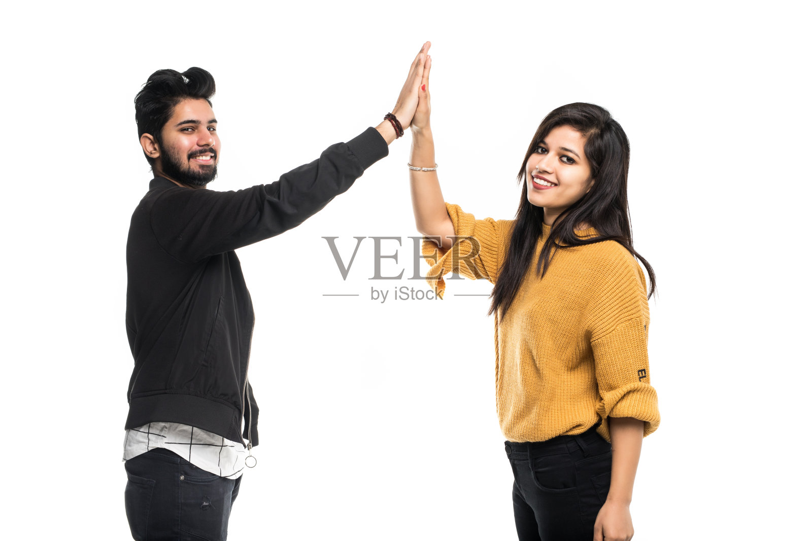 兴奋的年轻印度夫妇在灰色背景上击掌照片摄影图片