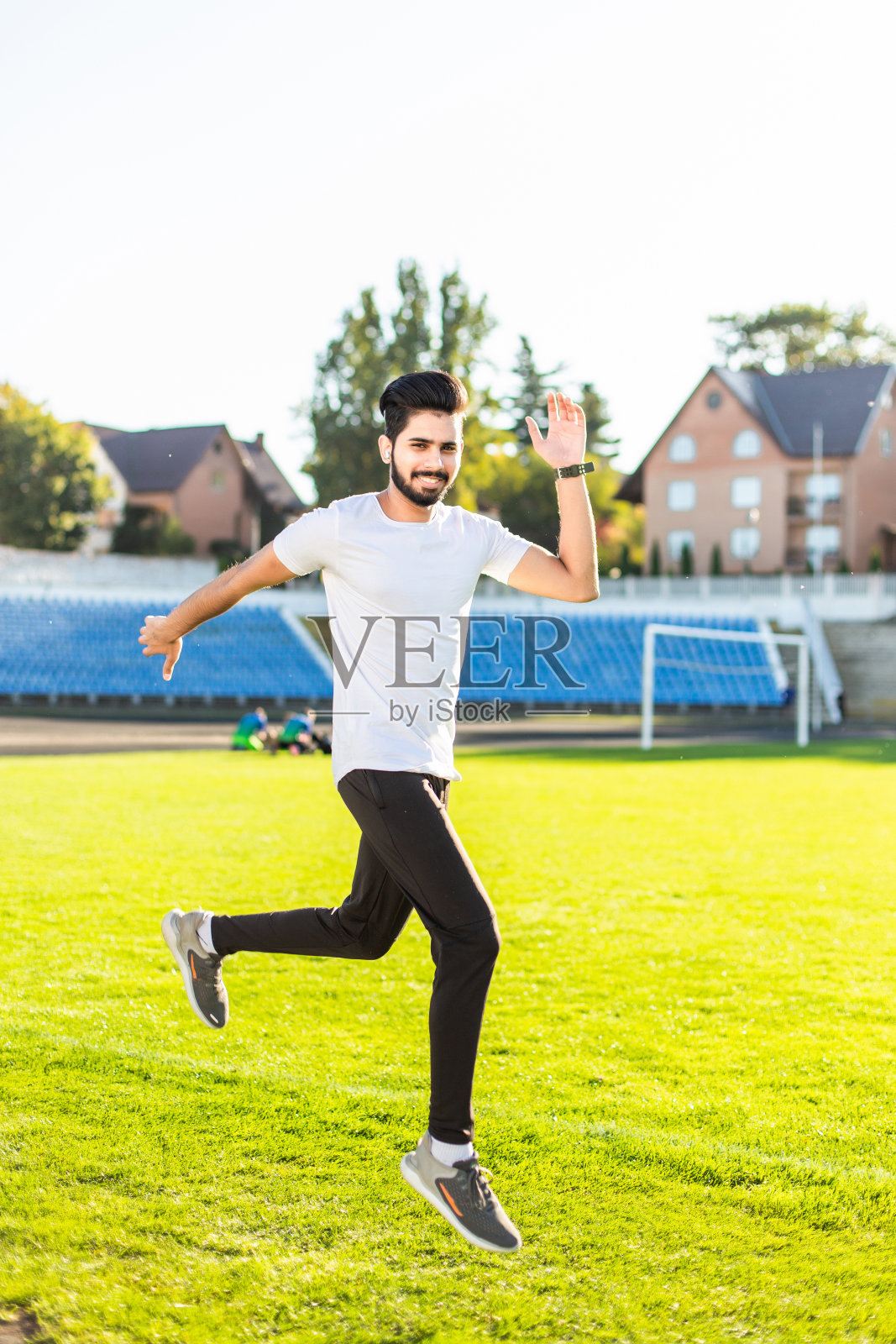 在体育场跳跃的印度年轻帅哥照片摄影图片