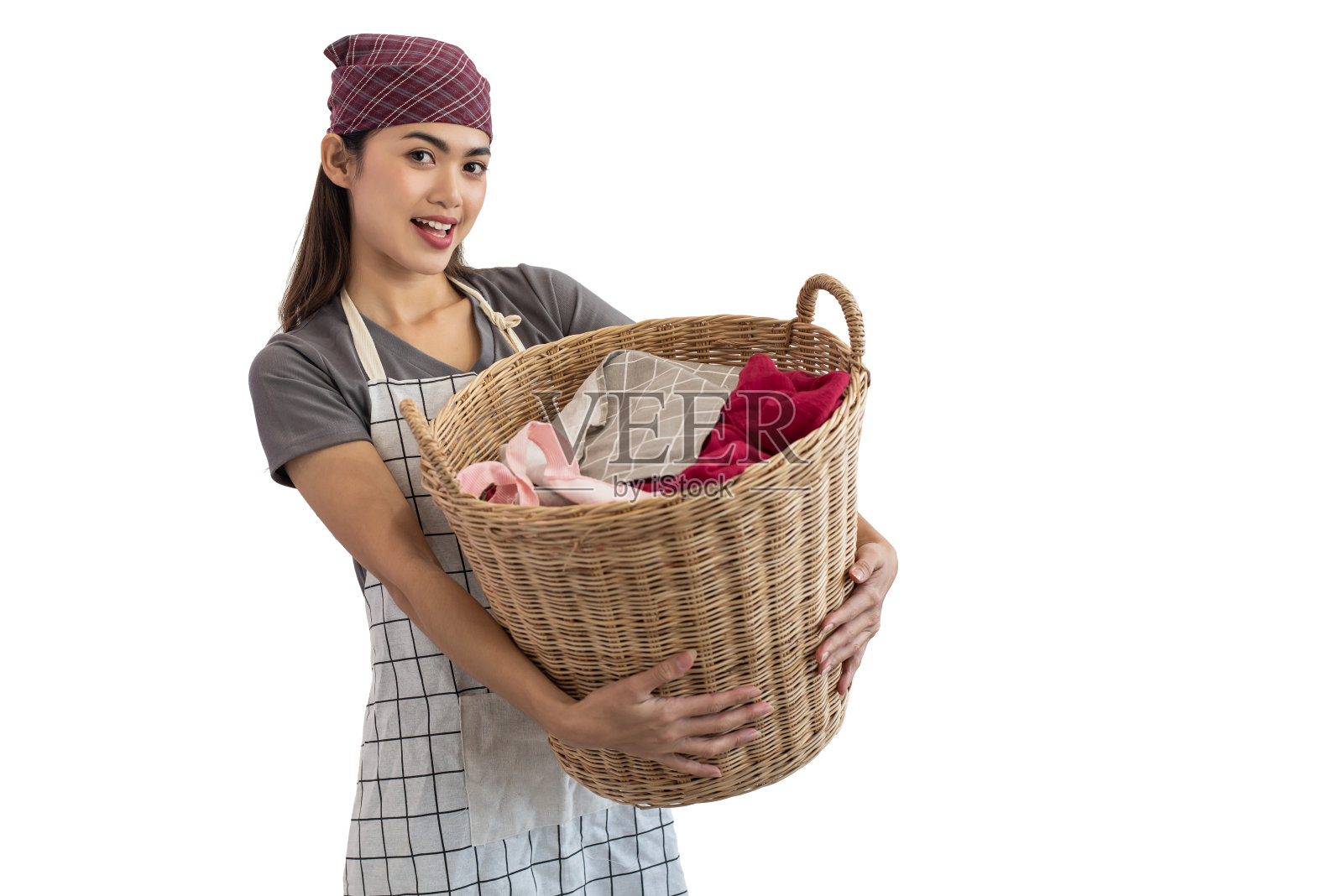 年轻的亚洲女性抱着洗衣篮，白色背景照片摄影图片