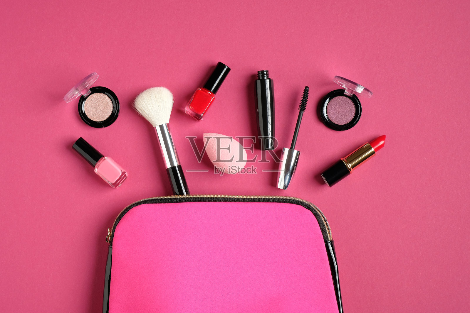 粉色背景的化妆包。平躺，俯视图。美丽和时尚的概念。照片摄影图片