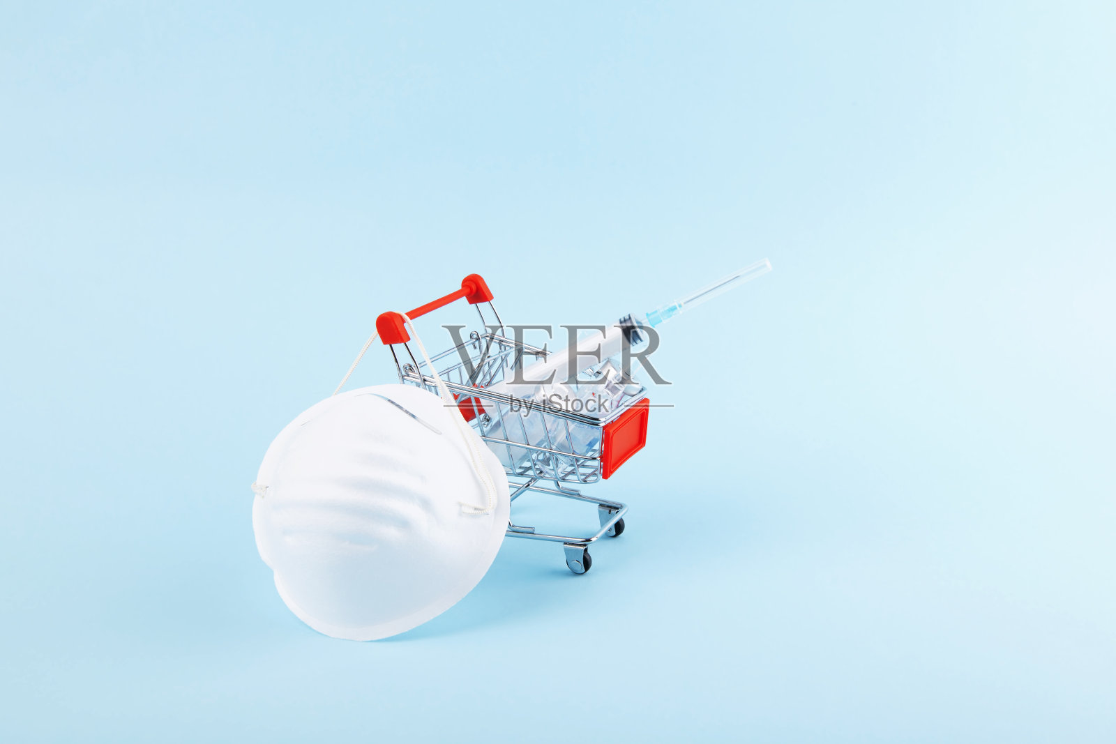 冠状病毒保护概念。迷你购物车药品，注射器和医疗面罩。购物时戴上口罩，防止冠状病毒感染。保健和外科概念照片摄影图片