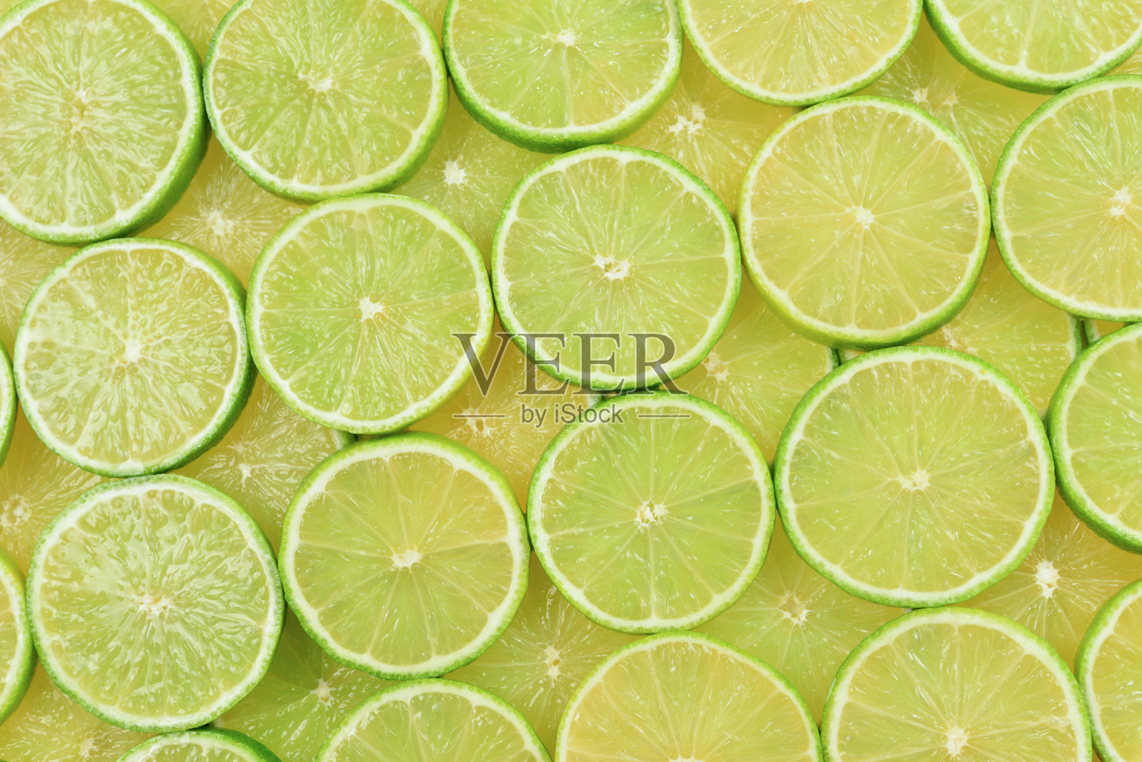 新鲜的酸橙片作为背景。照片摄影图片