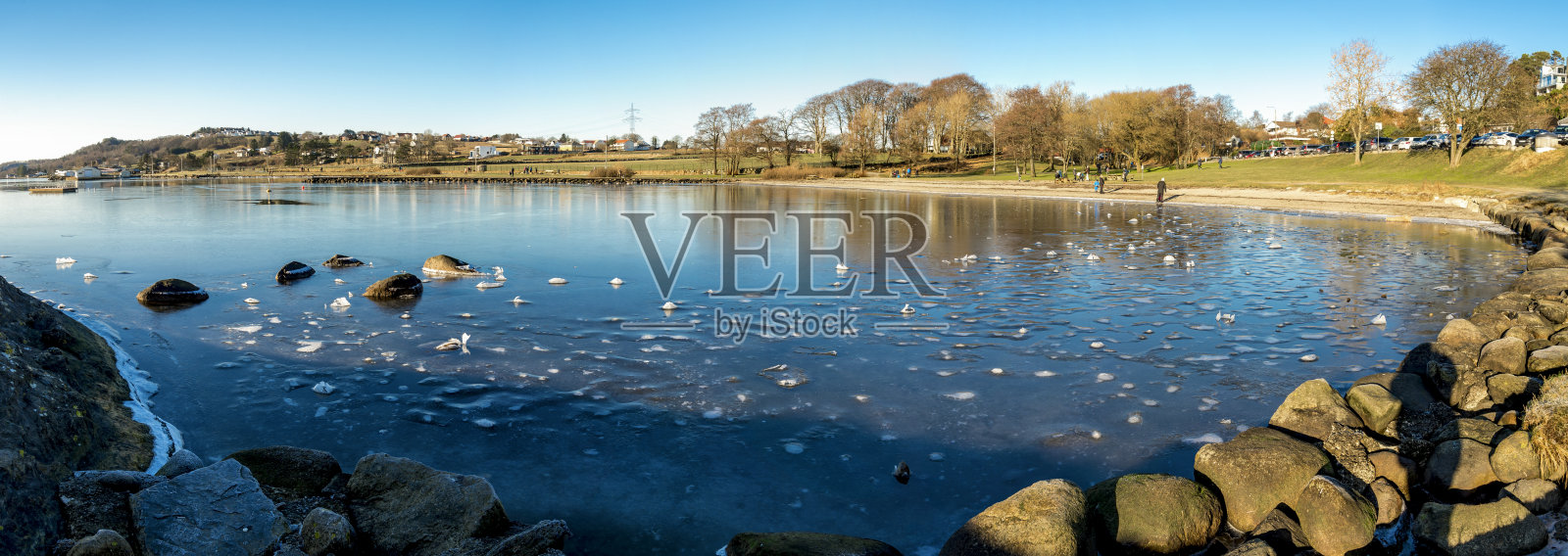 斯塔万格，在寒冷的冬季，“Sverd i Fjell”纪念碑附近的哈夫斯峡湾(hafrsjord)冰冻水域中的岩石和冰柱照片摄影图片