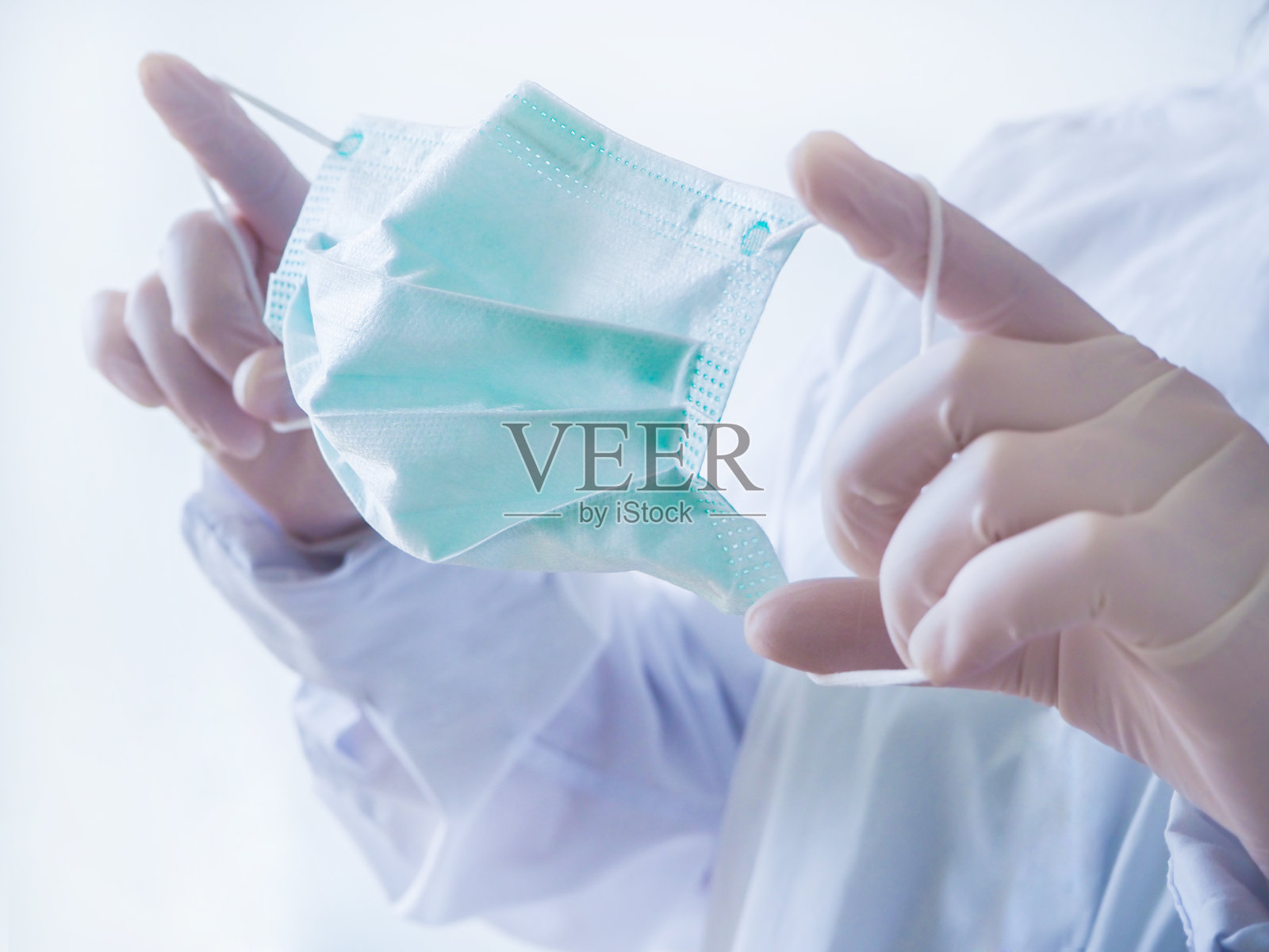 流行的冠状病毒。手拿口罩，防止病毒感染。照片摄影图片