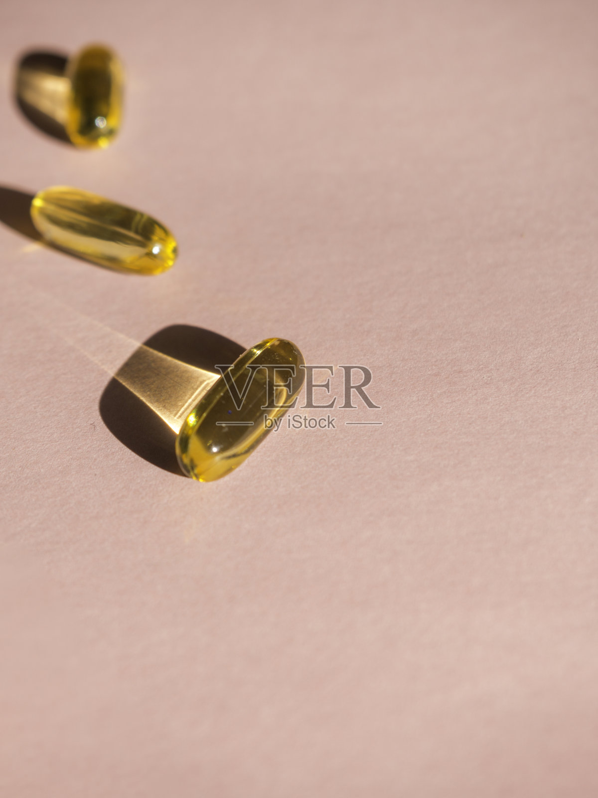 油黄色胶囊在粉红色的背景照片摄影图片