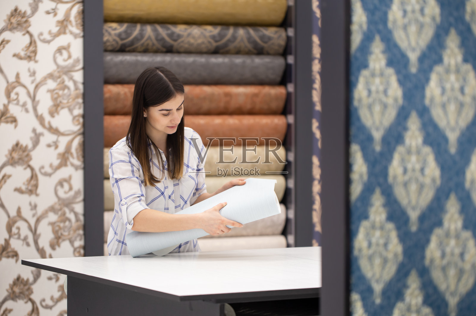 年轻女子在商店里为她的家选择壁纸照片摄影图片