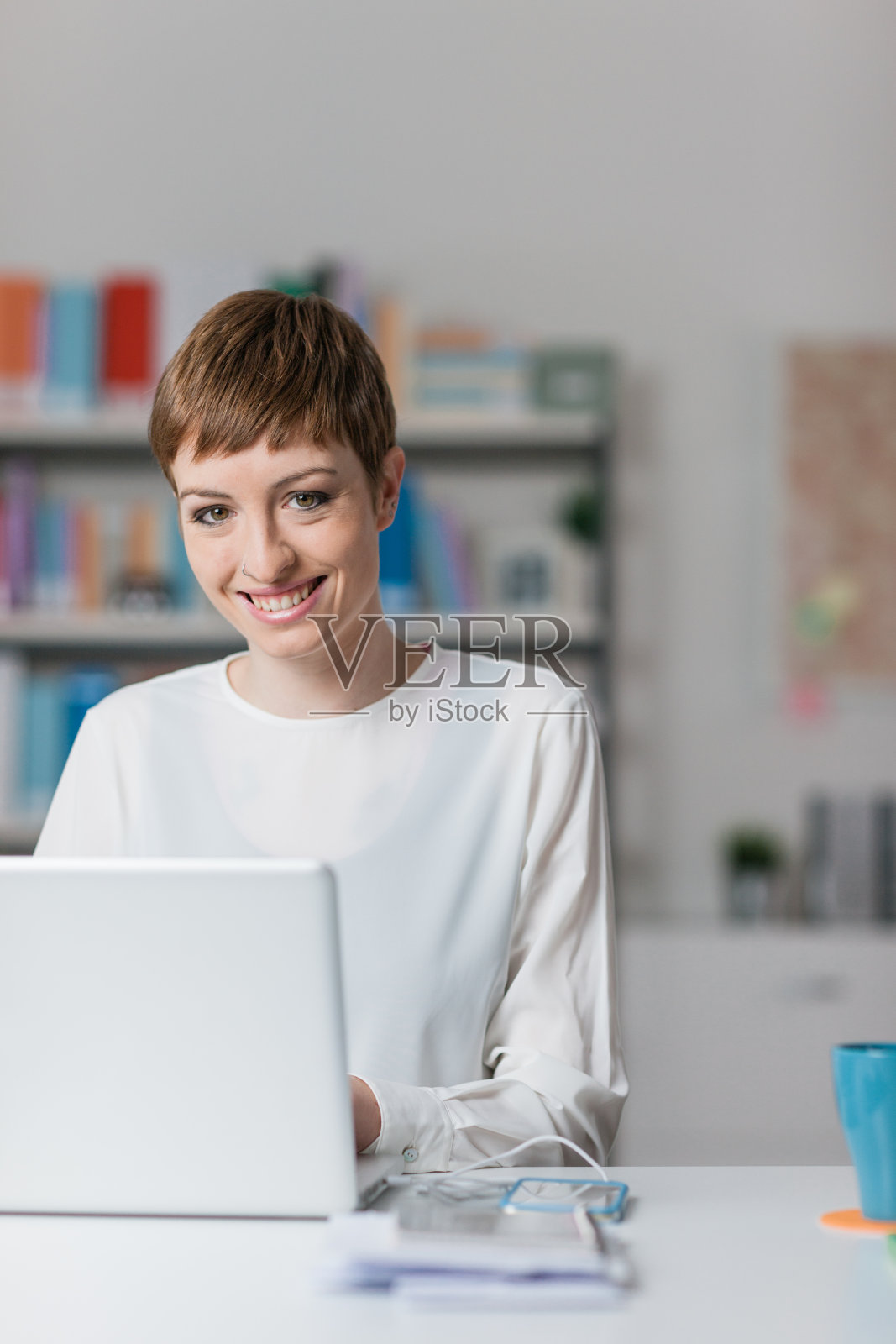 微笑的女人在用笔记本电脑照片摄影图片