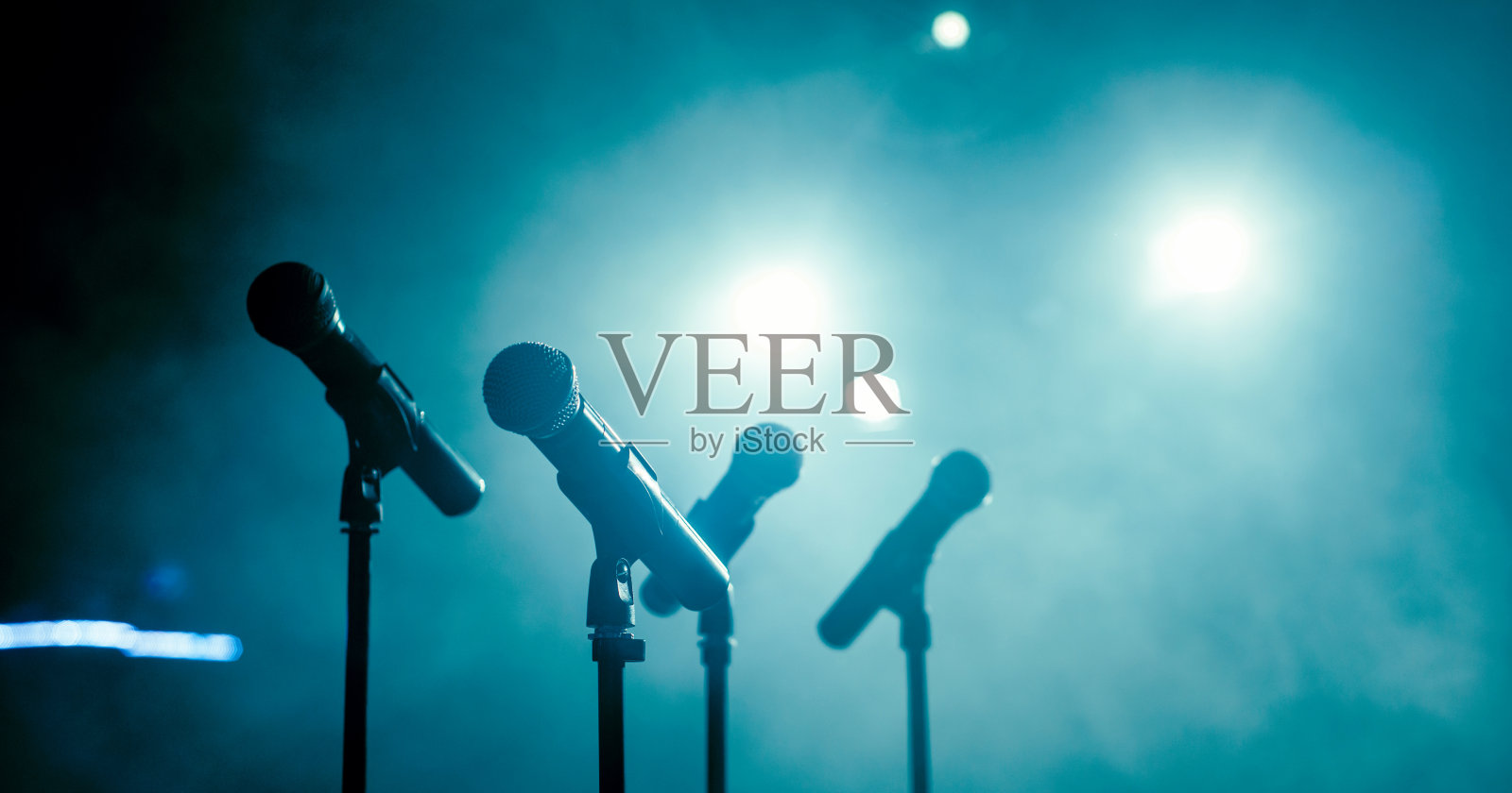 在有聚光灯的黑暗俱乐部里有四个麦克风照片摄影图片