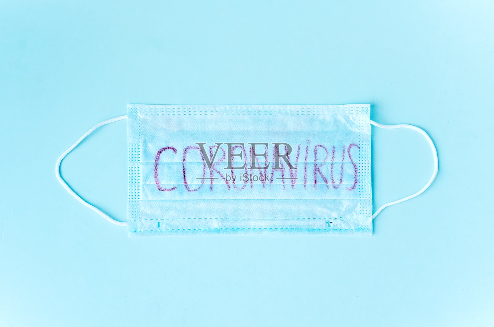 外科口罩，蓝色背景上刻有冠状病毒的防护口罩。2019 nKoV病毒感染照片摄影图片