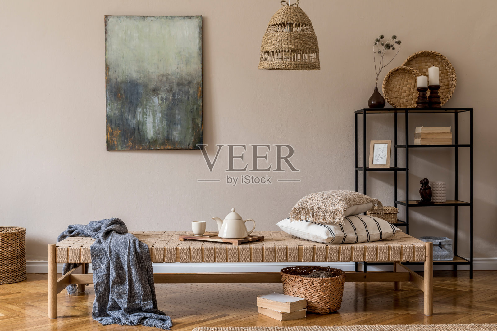 东方风格的客厅室内设计以现代的躺椅、靠枕、格子、藤条装饰、现代的搁板、优雅的个人配饰和米色墙壁上的模拟画。照片摄影图片