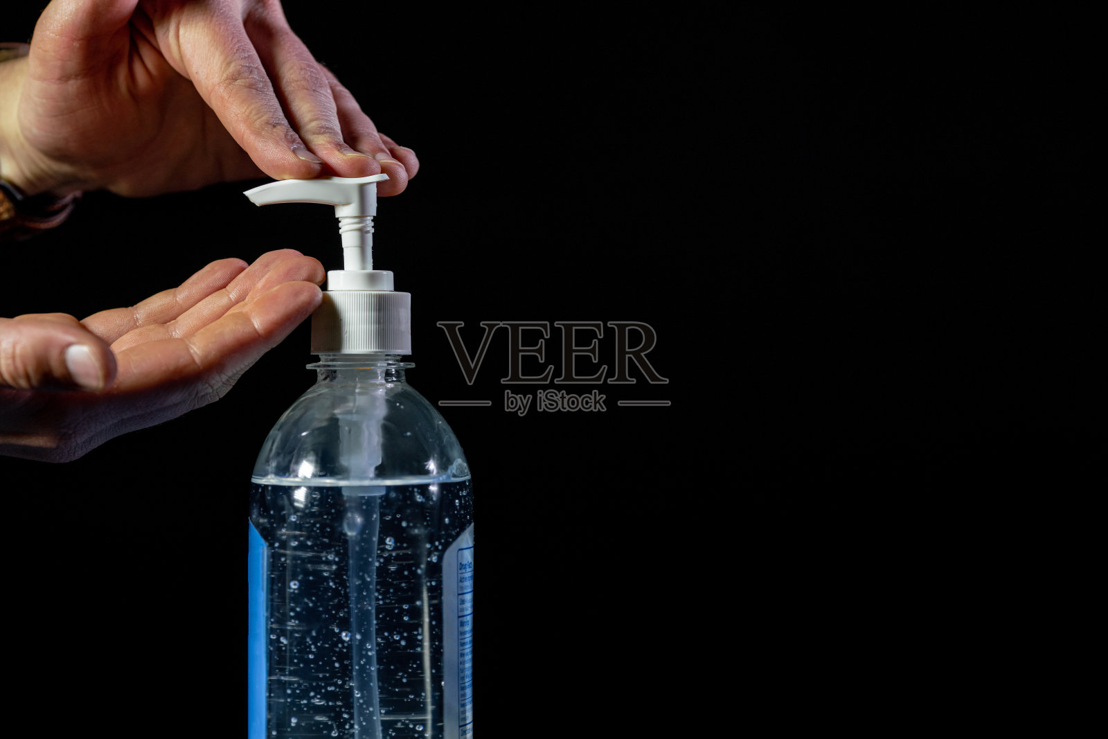 特写镜头白人男性的手即将泵小流量的凝胶洗手液与酒精和芦荟防止COVID SARS nCoV 19冠状病毒猪流感H7N9流感疾病在寒冷和流感季节的背景照片摄影图片