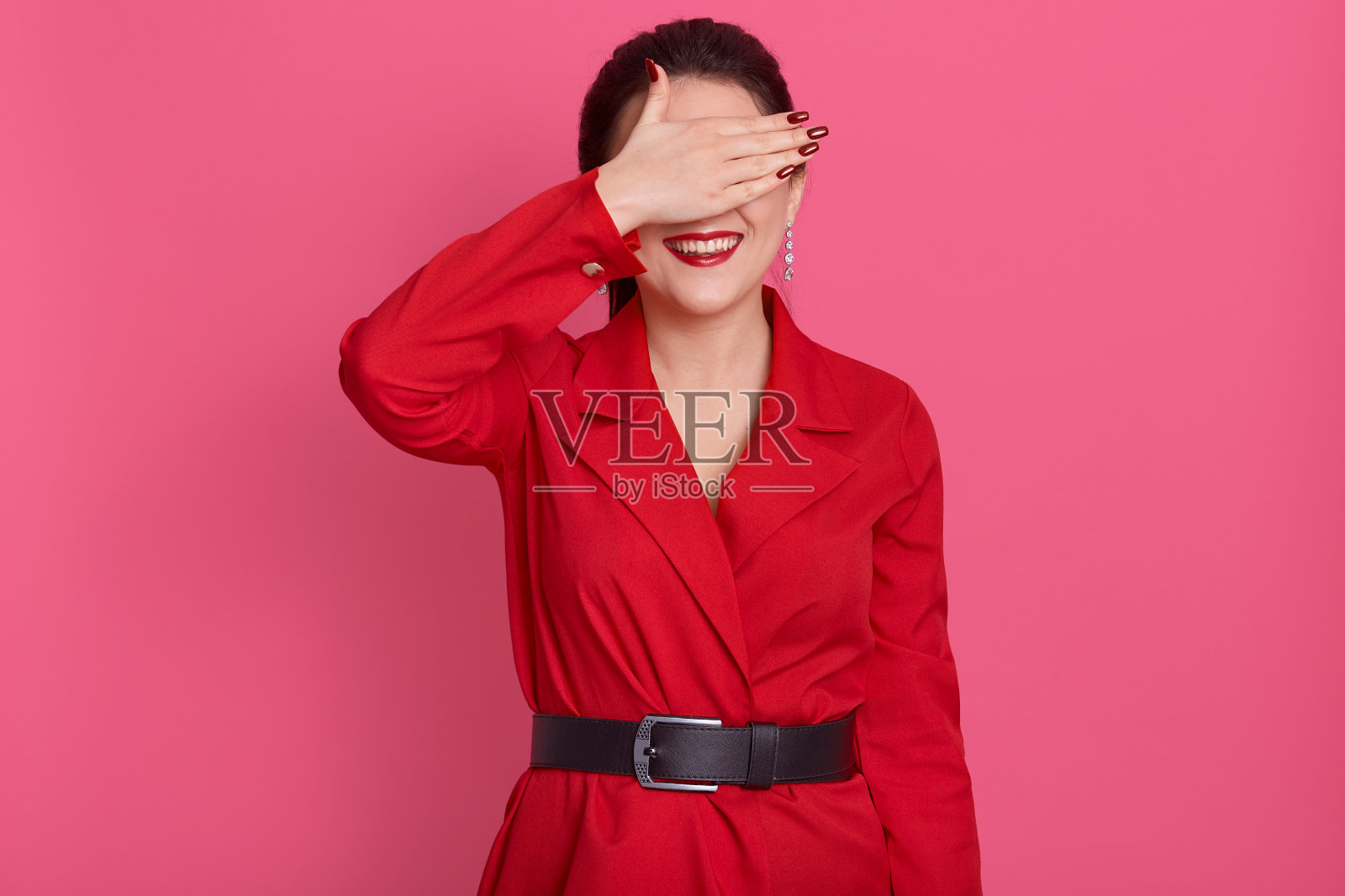 棕发女子遮眼：身穿红裙的可爱美女照片摄影图片