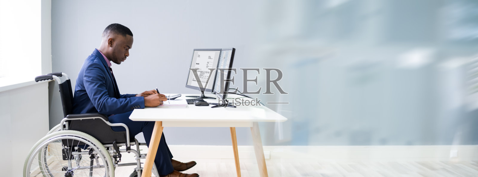 坐在轮椅上工作的非洲残疾会计师照片摄影图片