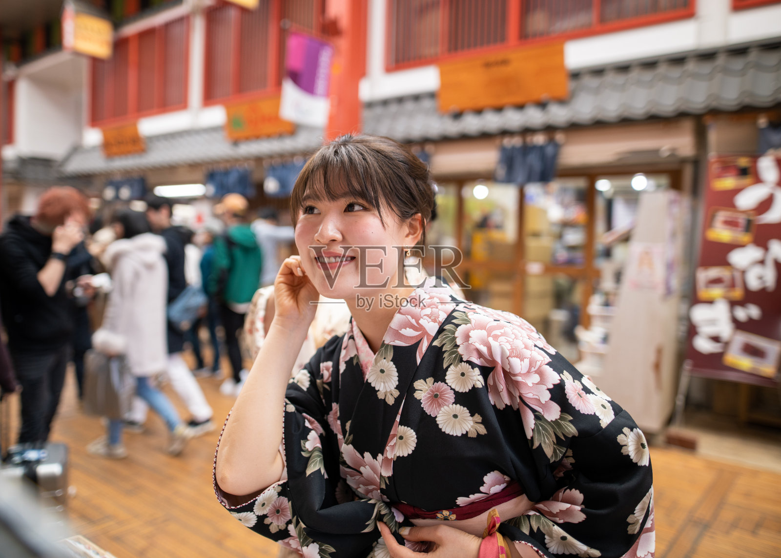 穿着和服的年轻女子在传统的日本购物中心购物照片摄影图片