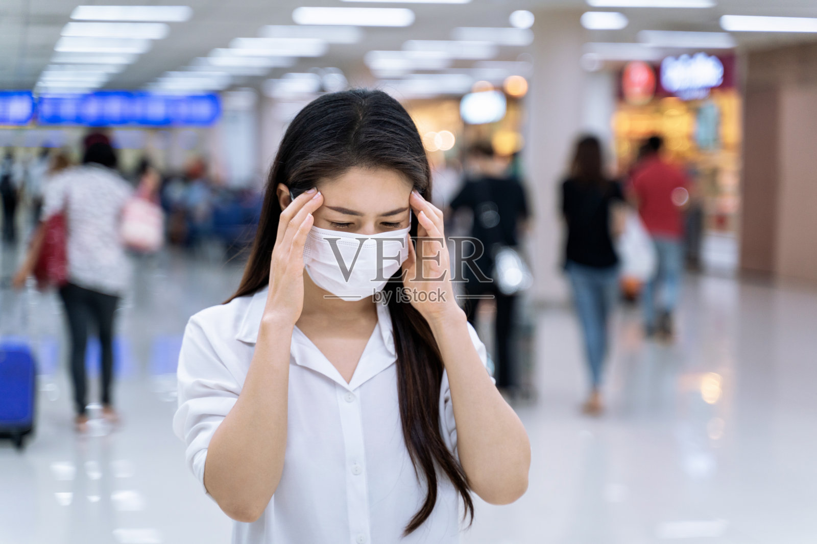 戴着口罩预防冠状病毒头痛的女人照片摄影图片