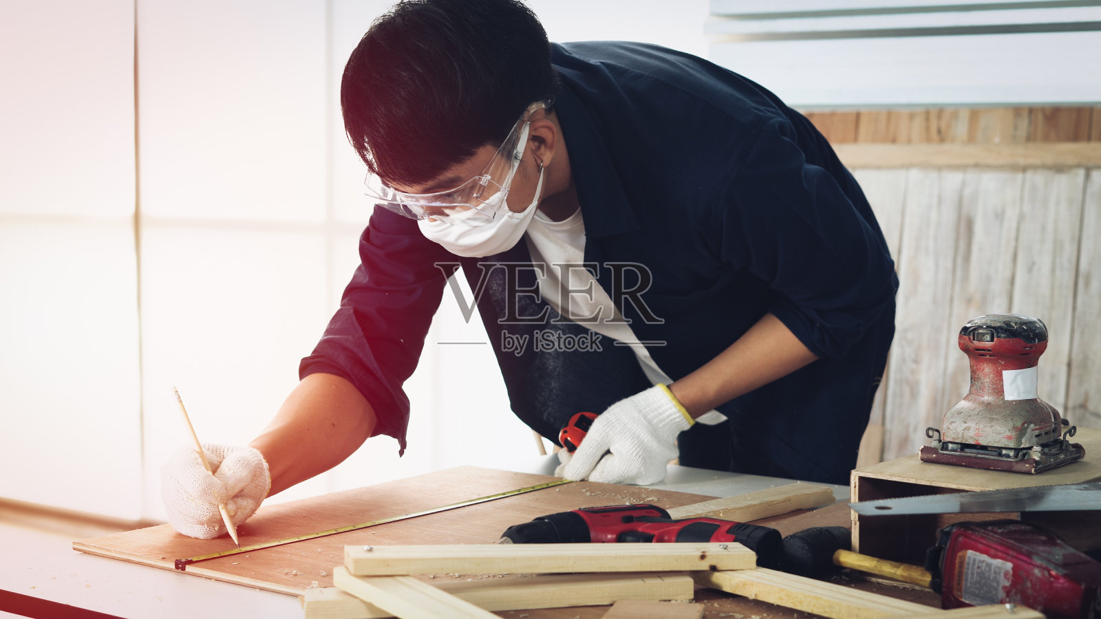 木匠用一个方框在家具零件上标记一个洞照片摄影图片