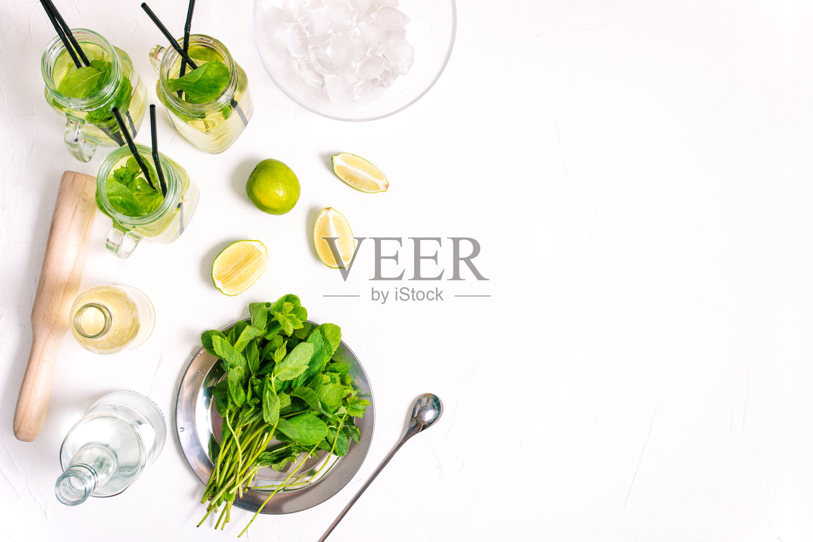 三杯鸡尾酒装夏季莫吉托酒精饮料。烹饪莫吉托。夏日鸡尾酒的配料放在有复印空间的桌子上。照片摄影图片