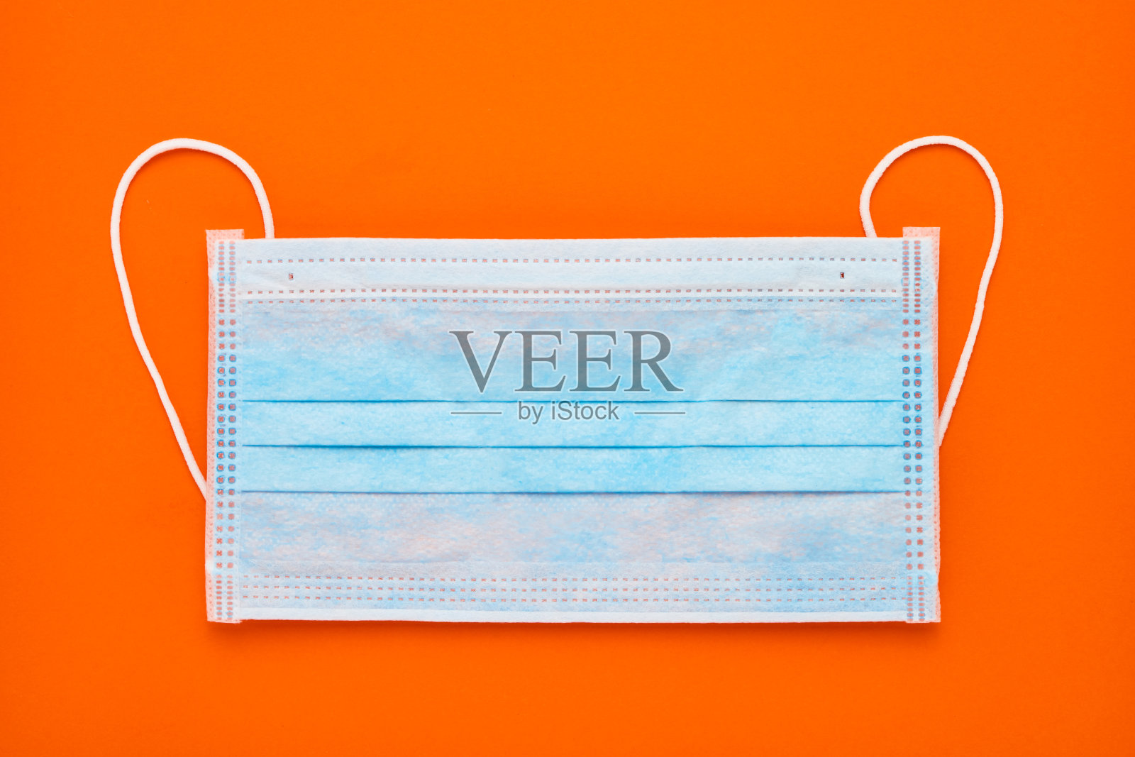 橙色背景的蓝色医用防护口罩。医疗保健和医疗理念。俯视图，复制空间照片摄影图片