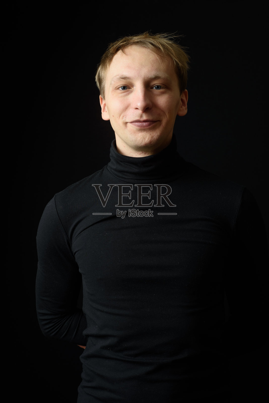 身穿黑色衬衫，背景为黑色的果断英俊男子肖像照片摄影图片