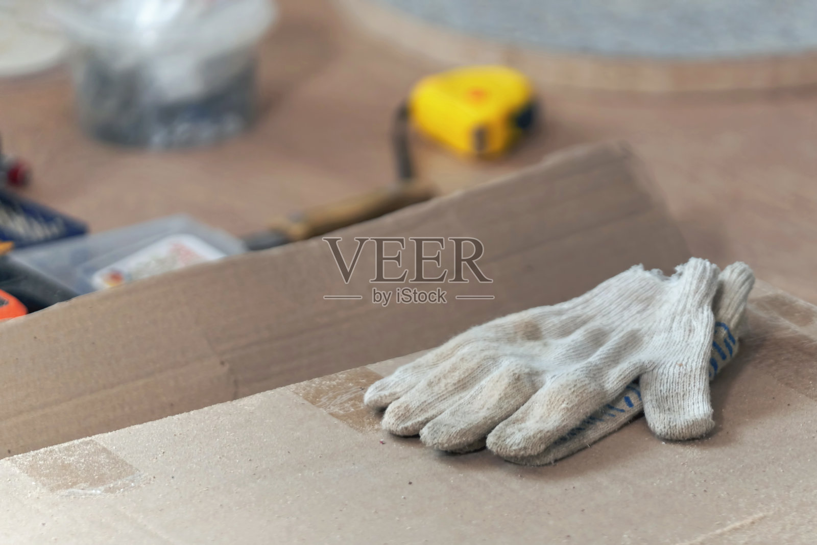 肮脏的施工手套躺在纸箱上，特写。用过的破布手套照片摄影图片