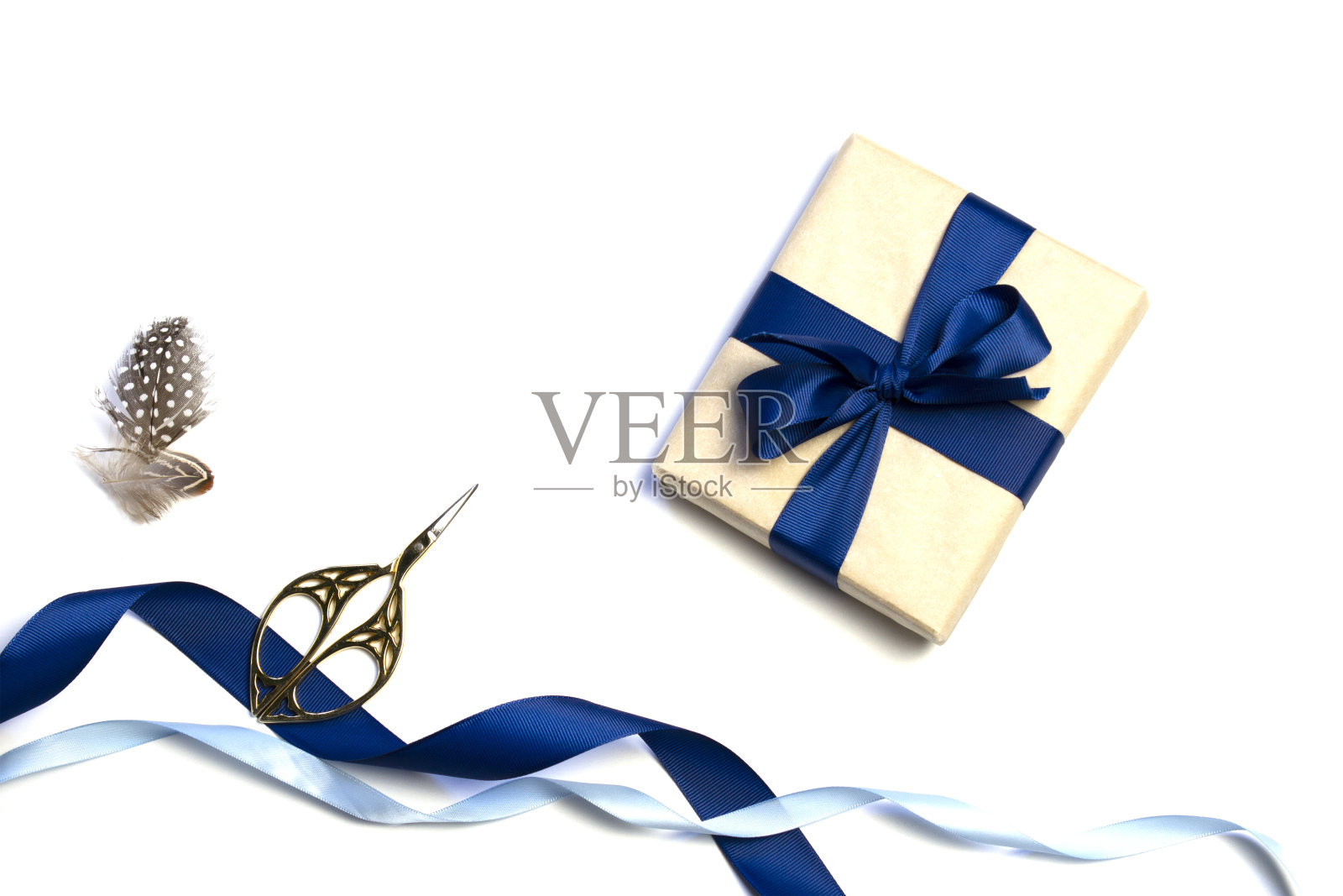 由包装好的礼物、牛皮纸和蓝色丝带在白色背景上分开组成的组合。从上往下看。对模型的邀请。照片摄影图片