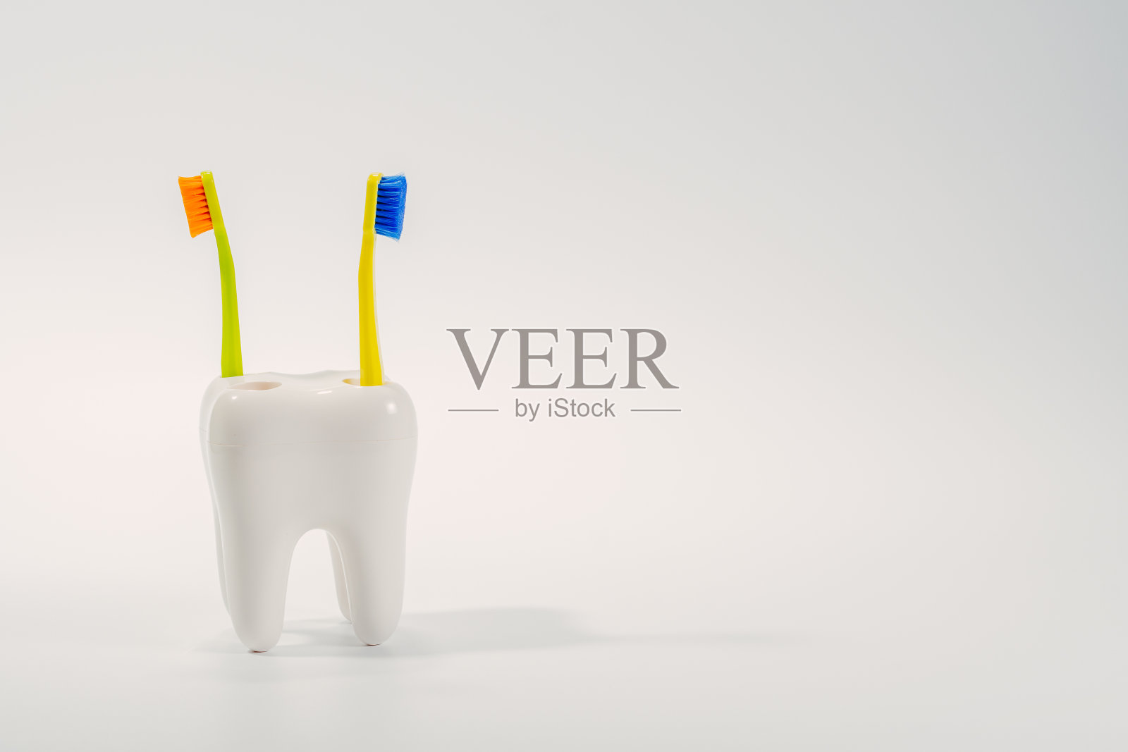 牙刷。牙刷放在一个大牙齿形状的架子上。照片摄影图片