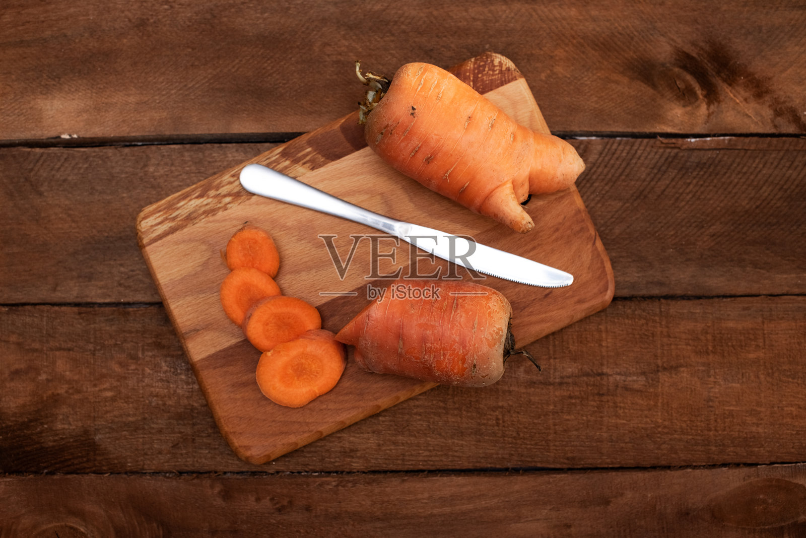 时髦丑陋的有机胡萝卜，从家庭花园床上谷仓的木头桌子，澳大利亚种植。Color-toning应用效果。照片摄影图片