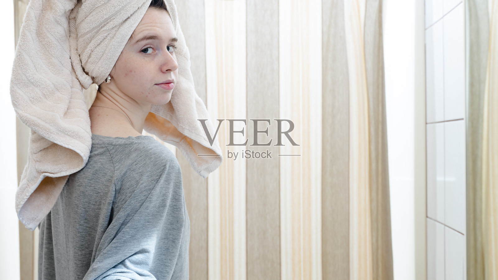 在浴室里用浴巾擦头发的年轻女人照片摄影图片