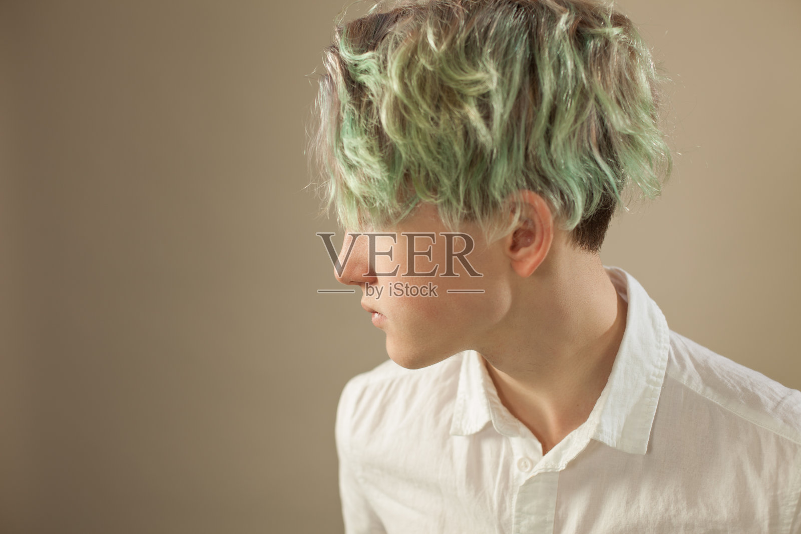 米色背景下的绿发少年棚拍写真照片摄影图片