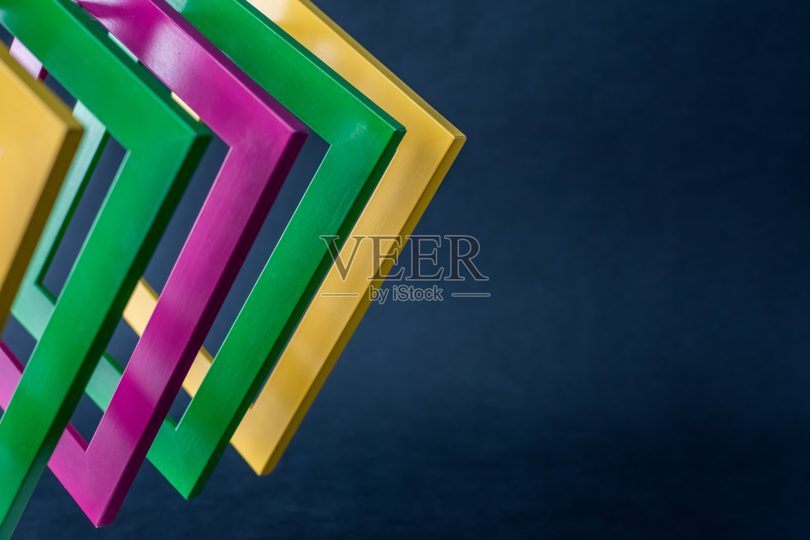 黄色、绿色和红色的木制相框在黑暗的背景上照片摄影图片