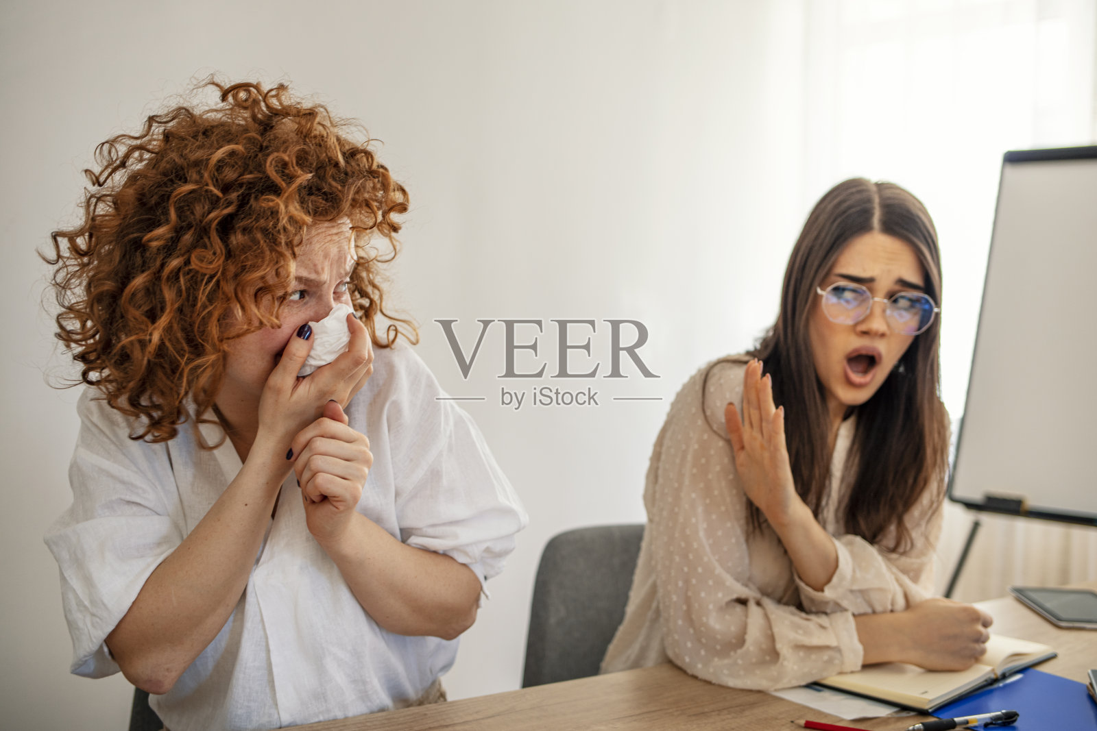 生病的女商人正在会议室擤鼻涕照片摄影图片