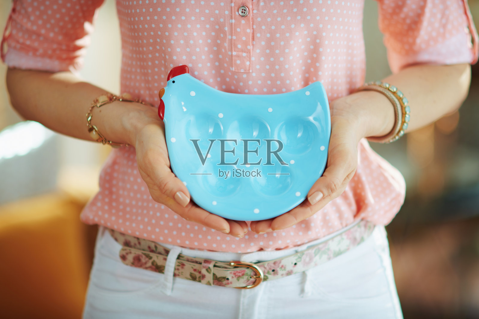 优雅的家庭主妇展示用蓝色的鸡形盘子盛鸡蛋照片摄影图片