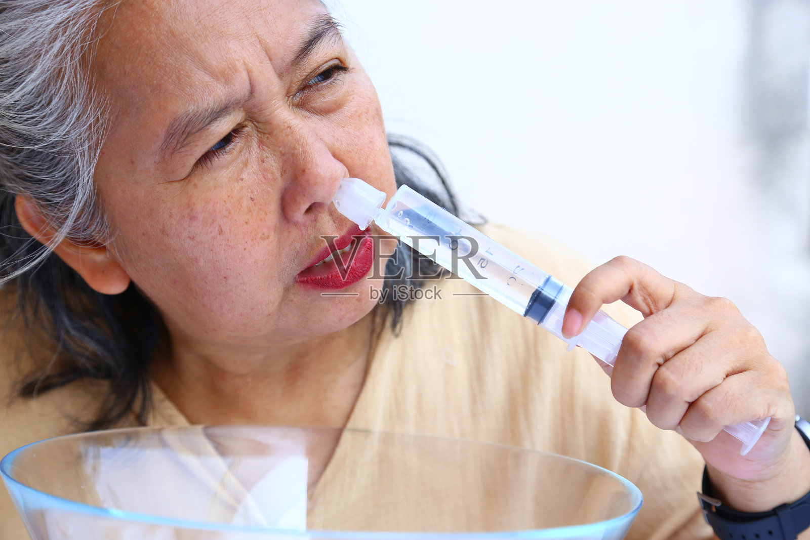 亚洲老妇用盐水洗鼻子照片摄影图片