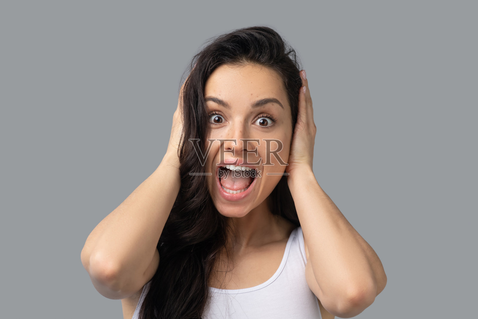 漂亮的黑发女孩穿着白色上衣看起来很震惊照片摄影图片