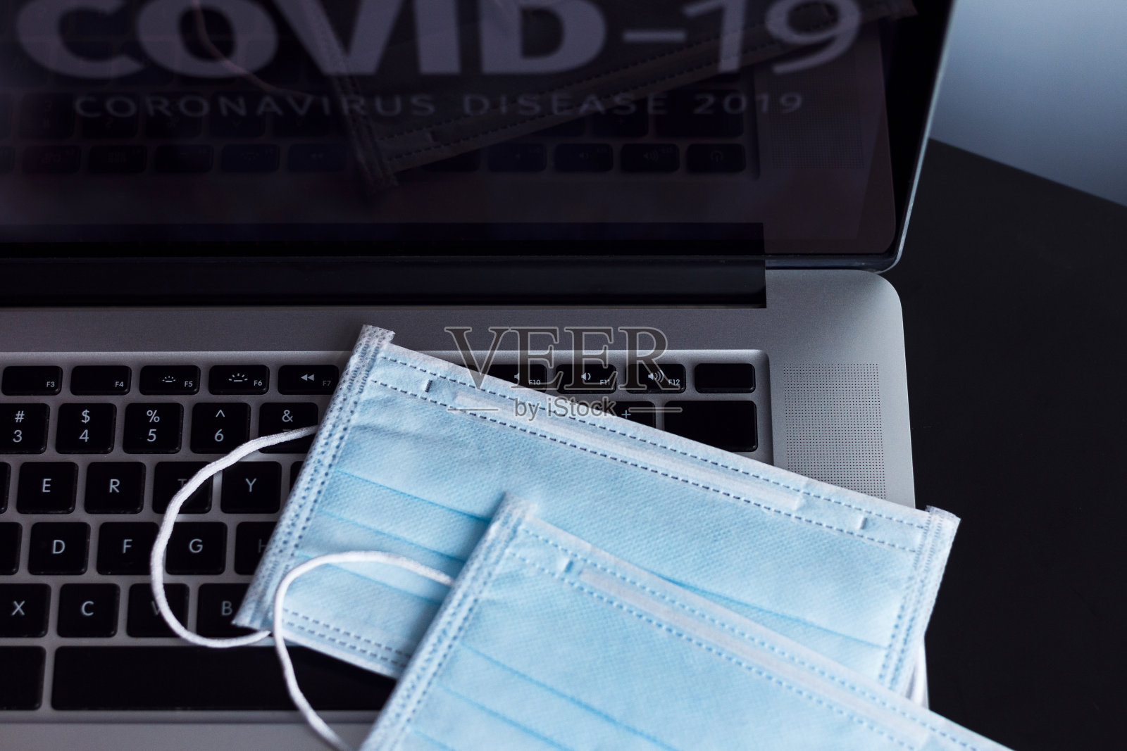 医用口罩放在电脑上照片摄影图片