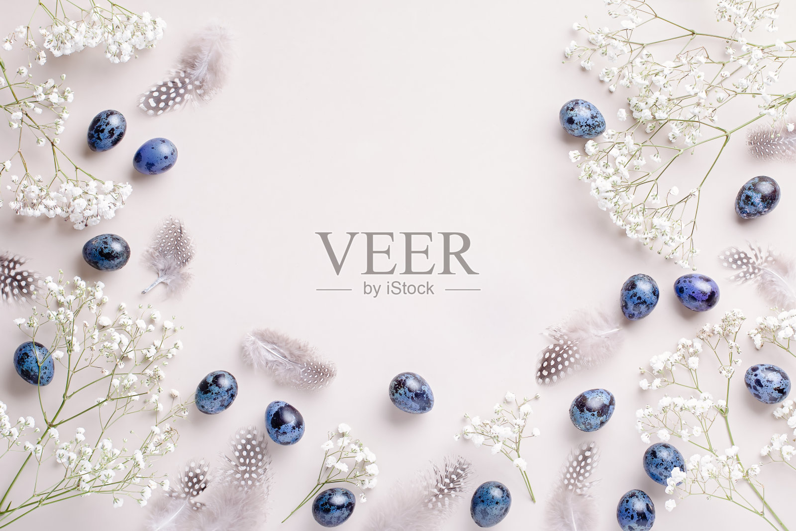 复活节画框用鹌鹑蛋涂成蓝色，羽毛和石竹花平躺着，光线坚硬，阴影粗糙，复制空间。中性背景的节日贺卡，俯视图照片摄影图片