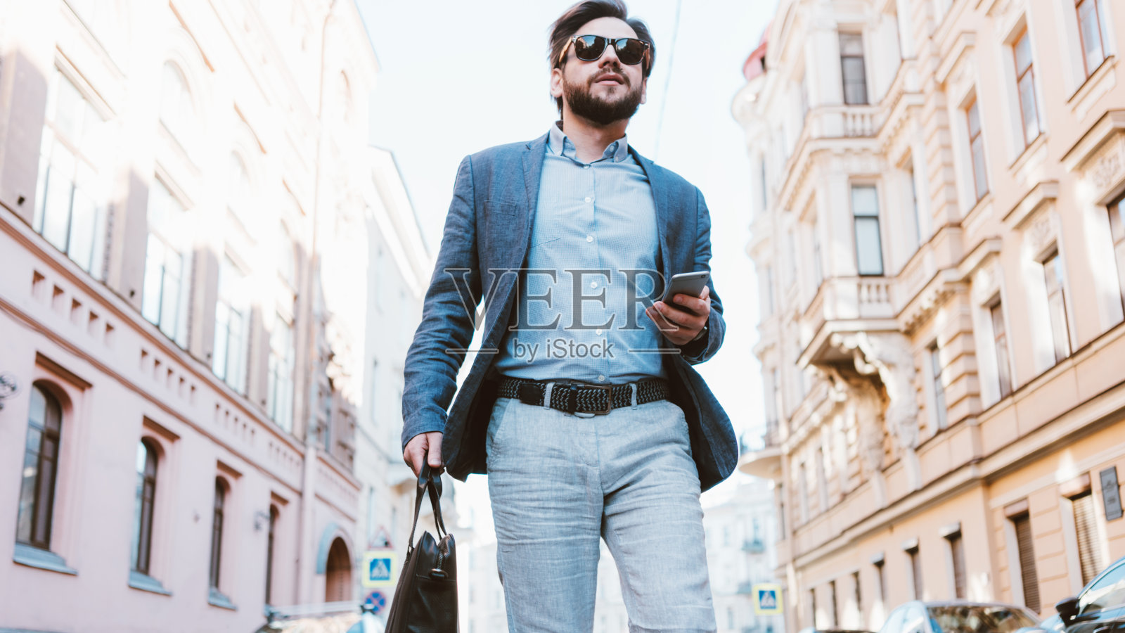 在城市街道上匆忙行走的年轻英俊商务男士照片摄影图片