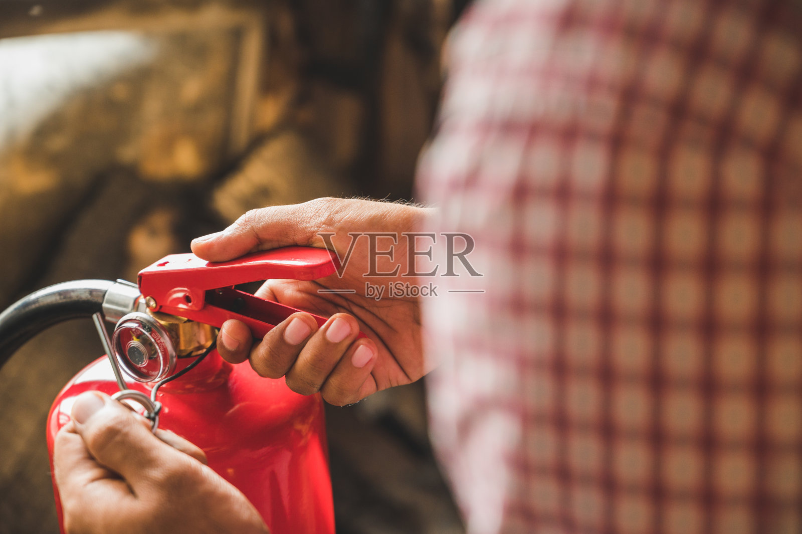 近距离使用灭火器灭火的消防员。灭火器手动拉销照片摄影图片