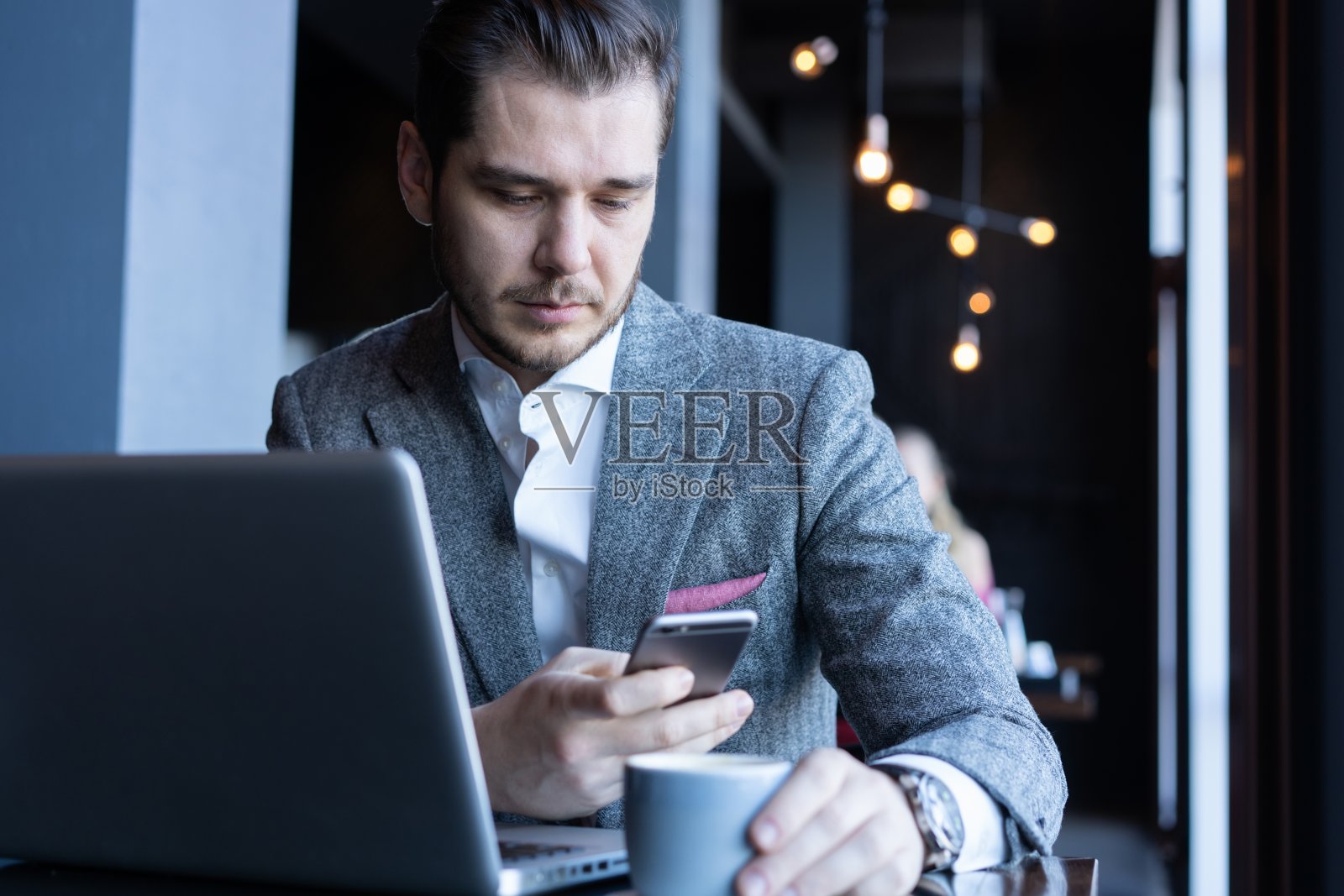 现代商务人士在午餐时间在咖啡馆喝浓缩咖啡并使用手机照片摄影图片