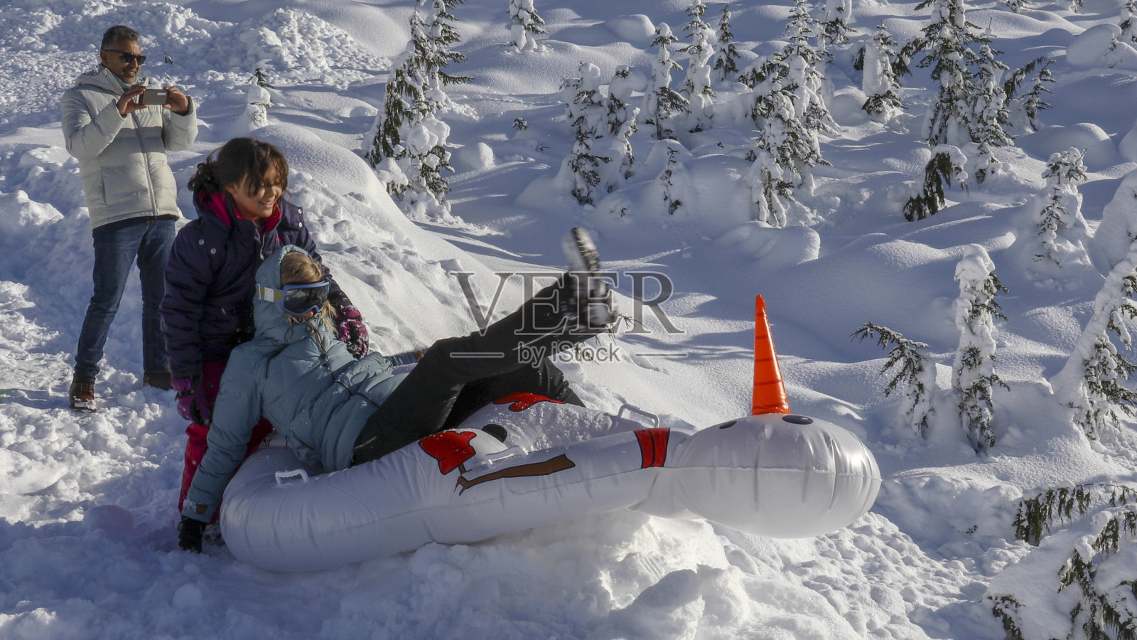 全家坐雪橇下山照片摄影图片