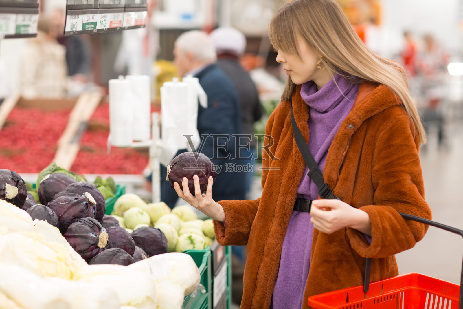 带着菜篮子的年轻女子在蔬菜区选择产品照片摄影图片
