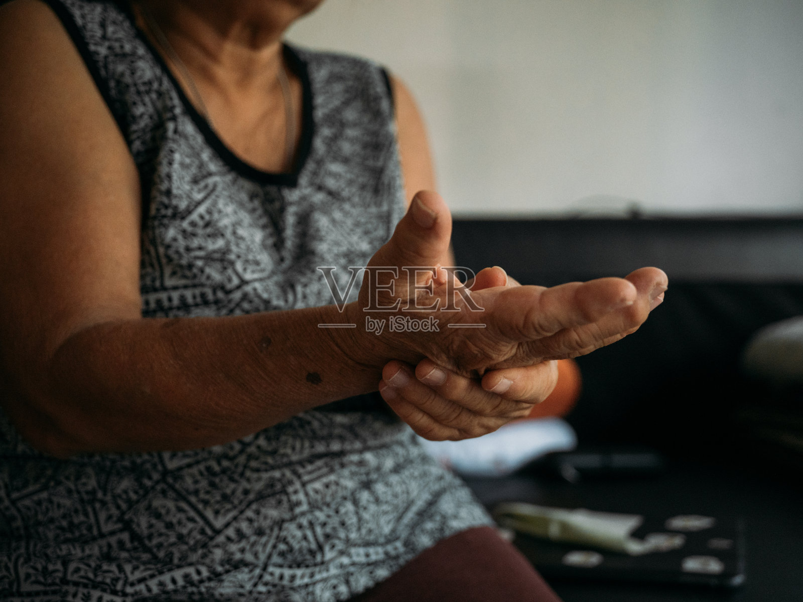 老妇人在家客厅用洗手液洗手。照片摄影图片