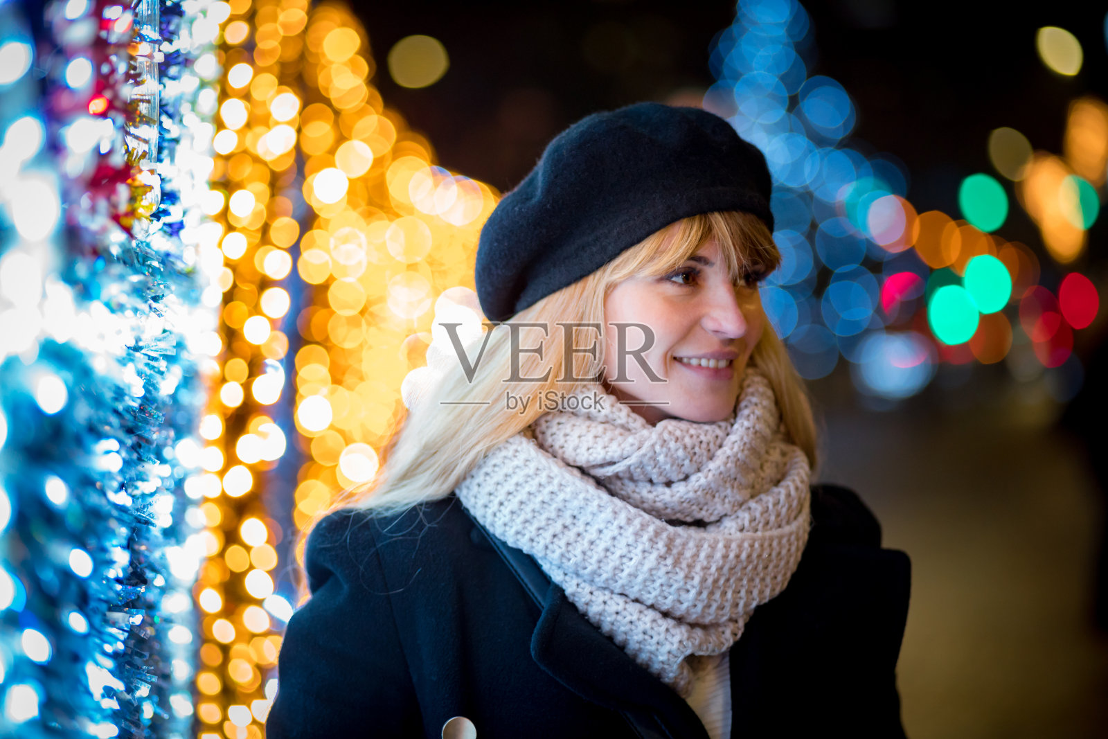 快乐微笑的女孩走在照亮的小巷在圣诞节照片摄影图片