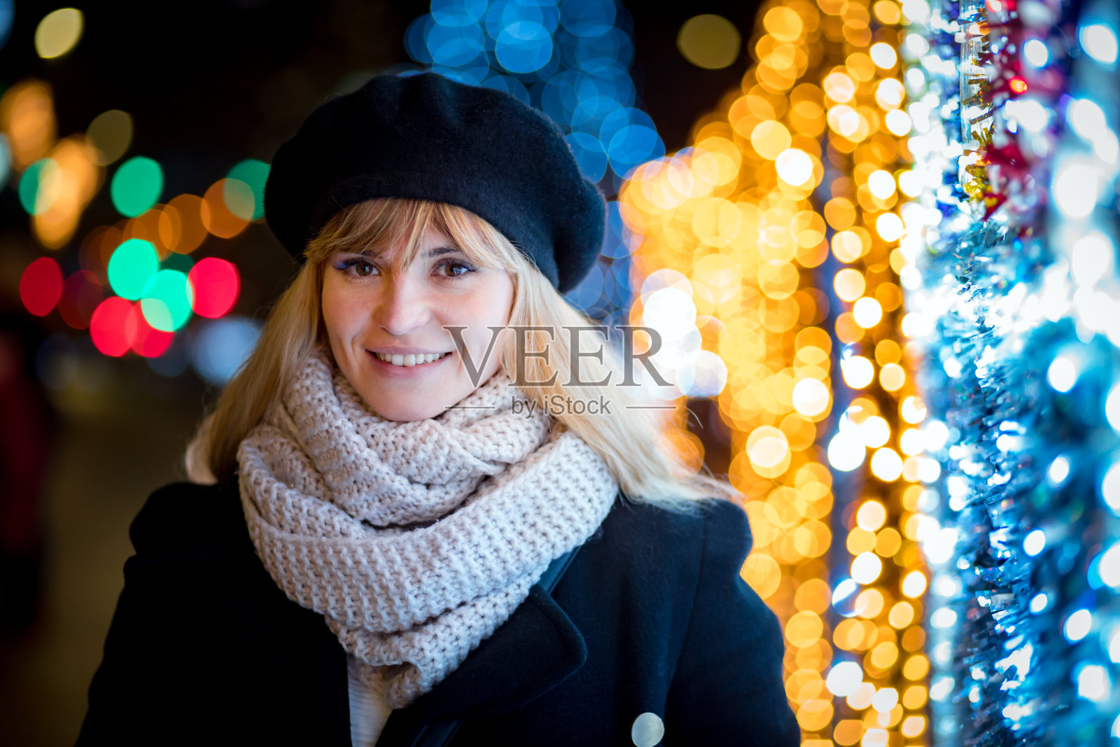 快乐微笑的女孩走在照亮的小巷在圣诞节照片摄影图片