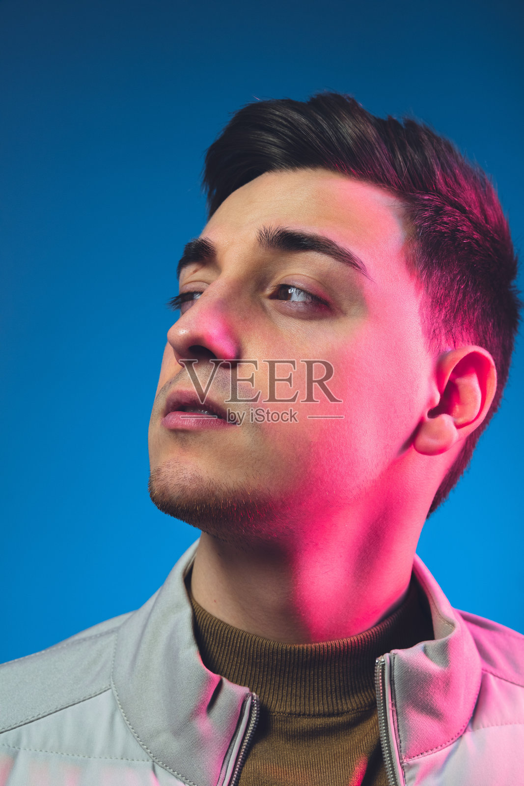 近距离白人男子的肖像孤立在蓝色的工作室背景霓虹灯照片摄影图片